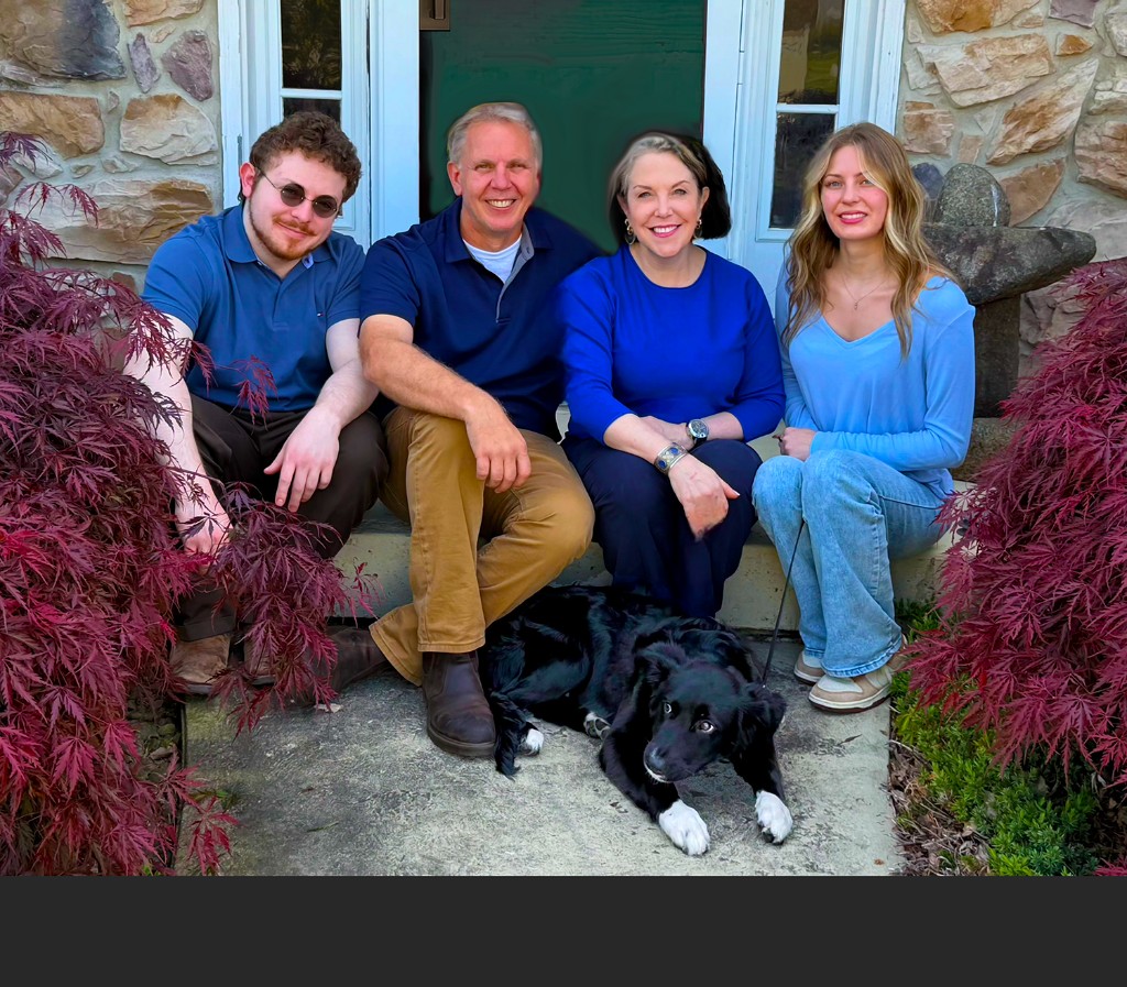Deirdre and Russ Todd with their two children and a dog on the front steps of their home