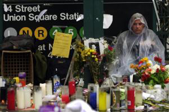 Candles and flowers at a memorial beneath the 14 Street Union Square Station subway sign